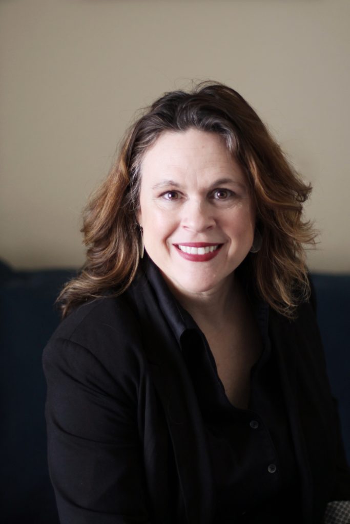 A person smiling for the camera
Description automatically generated